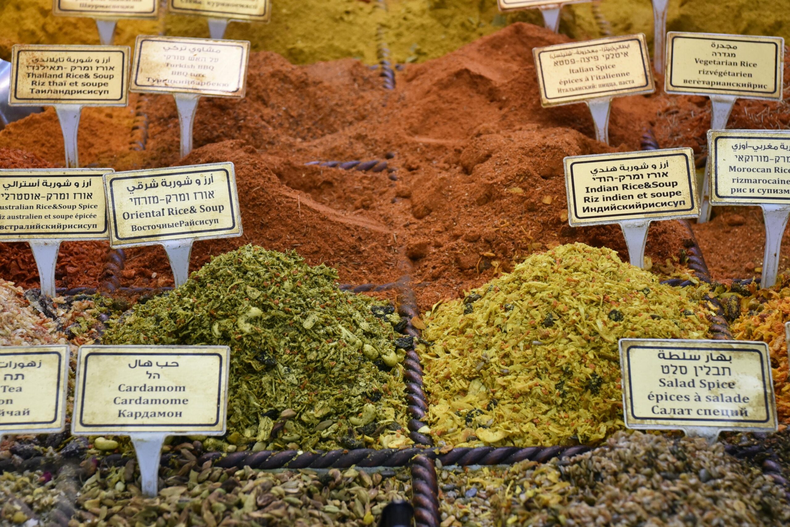 From above of collection of colorful aromatic dry condiments with titles in street market